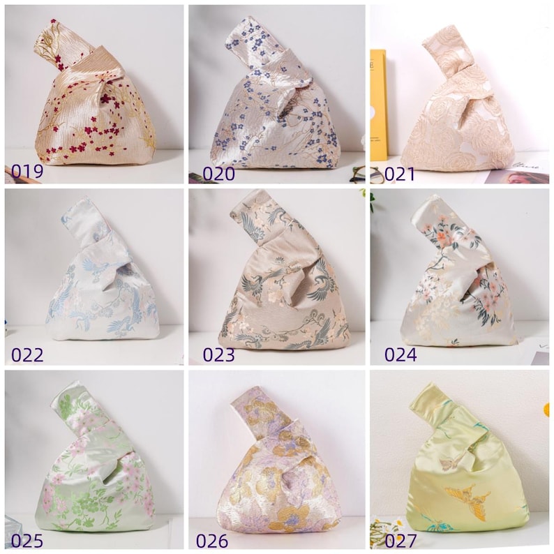 May include: A collection of nine Japanese knot bags in various colors and patterns. The bags are made of satin-like fabric and feature floral, bird, and abstract designs. Each bag has a unique color scheme, including cream, blue, pink, and gold.