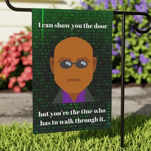 May include: A black and green garden flag with a cartoon image of a bald man wearing sunglasses and a purple shirt. The flag has the text "I can show you the door but you're the One who has to walk through it."