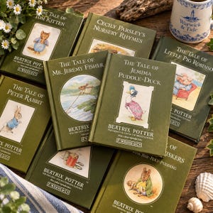 Op de afbeelding: Een verzameling groene hardcover boeken van Beatrix Potter, waaronder The Tale of Peter Rabbit, The Tale of Jemima Puddle-Duck, The Tale of Mr. Jeremy Fisher, The Tale of Tom Kitten, Cecily Parsley's Nursery Rhymes en The Tale of Little Pig Robinson.