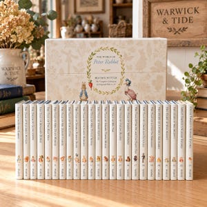 May include: A boxed set of 23 hardcover books titled The World of Peter Rabbit by Beatrix Potter. The cream-colored box features botanical illustrations and characters. Each book spine is white with a unique character icon and title.