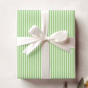 A gift is wrapped in wrapping paper with bright green and white pinstripes.