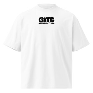 Può includere: Una t-shirt bianca a maniche corte con collo alto. Al centro del petto è presente una grafica nera con le lettere in grassetto GITC e il testo GETINTHECYPHER stampato in un carattere sans-serif più piccolo direttamente sotto le lettere.