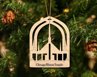 Puede incluir: Adorno navideño de madera con forma de iglesia con un símbolo de paz en el centro. El adorno está decorado con una silueta del Templo de Chicago Illinois. El texto "Chicago Illinois Temple" está impreso debajo de la silueta.
