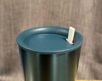 May include: A teal-colored stainless steel tumbler with a matching lid and a white straw. The tumbler has a sleek, cylindrical design and is suitable for cold beverages. The text "STAINLESS STEEL" is printed on the side.
