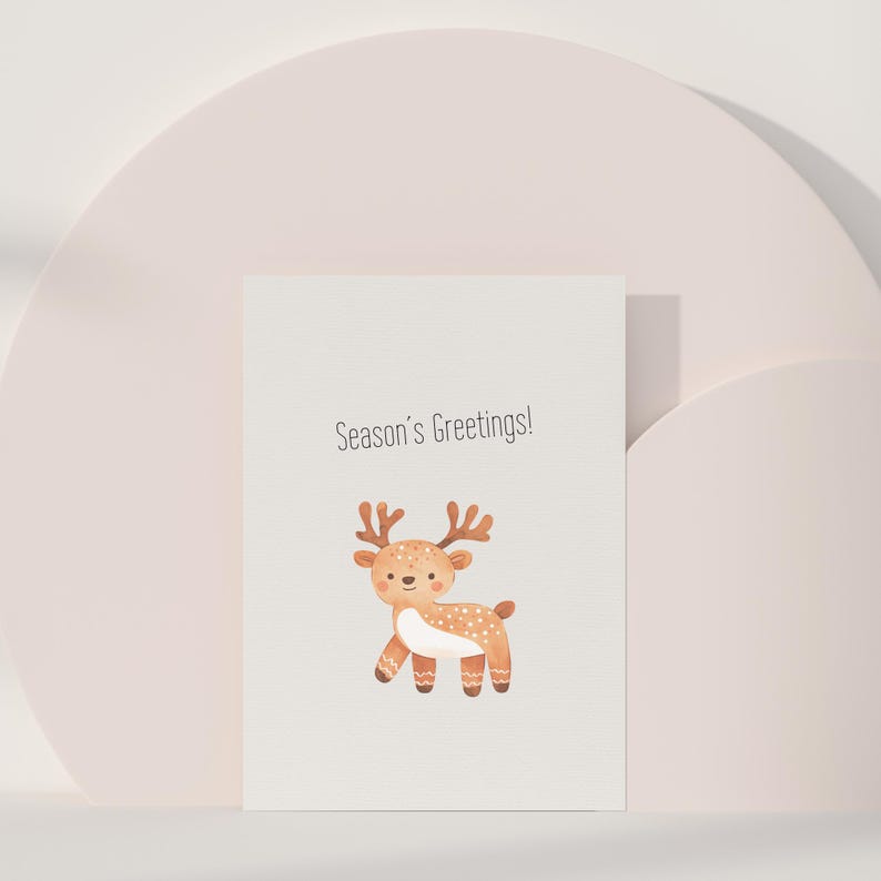 Puede incluir: Una tarjeta blanca con el texto "Season's Greetings!" y una ilustraci&oacute;n de dibujos animados de un reno marr&oacute;n con manchas blancas.