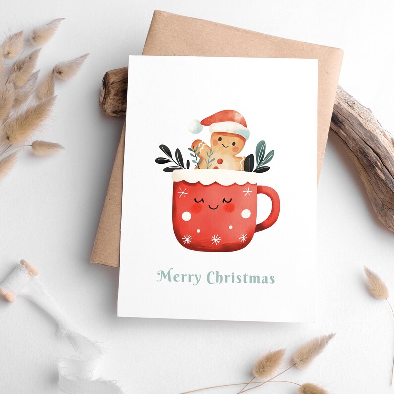 Puede incluir: Una taza roja con un borde blanco y copos de nieve blancos, un hombre de jengibre con un gorro de Pap&aacute; Noel est&aacute; dentro de la taza. La taza tiene una cara feliz y el texto "Feliz Navidad" est&aacute; debajo de la taza.