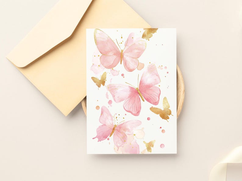 Puede incluir: Una tarjeta blanca con mariposas de acuarela rosa y dorada. Las mariposas est&aacute;n dispersas por la tarjeta con salpicaduras de pintura dorada.