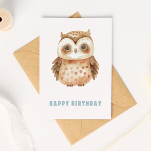 Pu&ograve; includere: Un'illustrazione ad acquerello di un gufo marrone con occhi grandi e un'espressione felice. Il gufo &egrave; su una carta bianca con il testo "Happy Birthday" in blu.