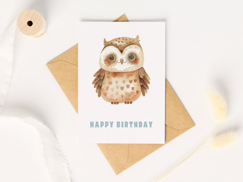 Pu&ograve; includere: Un'illustrazione ad acquerello di un gufo marrone con occhi grandi e un'espressione felice. Il gufo &egrave; su una carta bianca con il testo "Happy Birthday" in blu.
