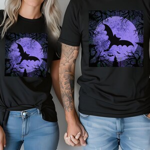 May include: Two black t-shirts with a purple moon and a black bat silhouette graphic. The moon has a textured, distressed look.