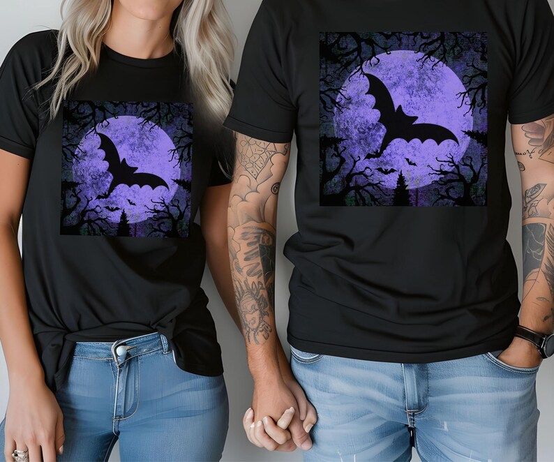 May include: Two black t-shirts with a purple moon and a black bat silhouette graphic. The moon has a textured, distressed look.
