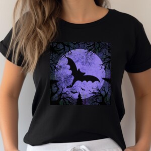 May include: Black t-shirt with a graphic of a bat flying in front of a purple moon and trees.