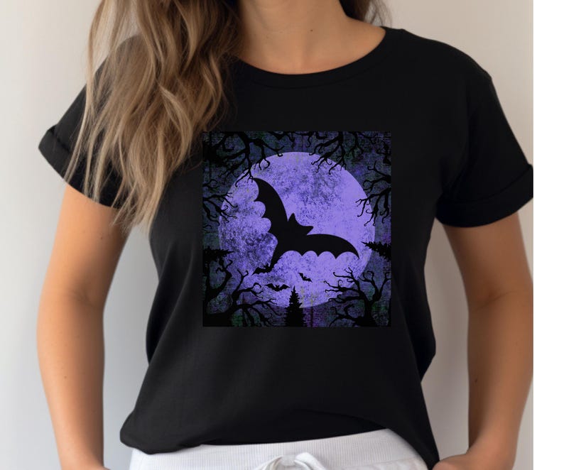 May include: Black t-shirt with a graphic of a bat flying in front of a purple moon and trees.