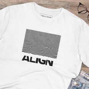 Peut inclure: T-shirt blanc avec un motif d'illusion d'optique noir et blanc et le mot "ALIGN" imprimé en dessous.