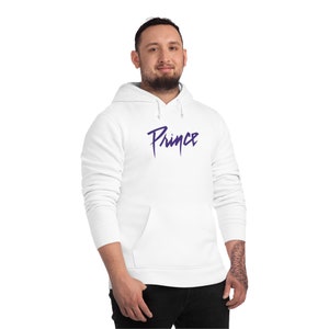 May include: White hooded sweatshirt with a purple Prince logo on the front.