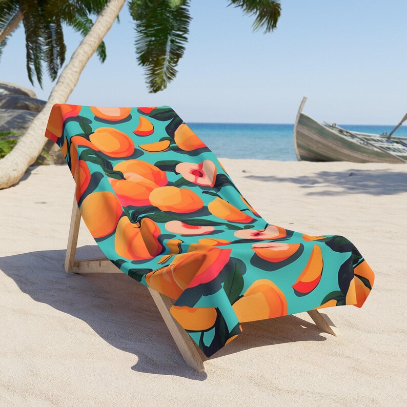 A colorful beach towel with an orange and green pattern is draped over a wooden chair on a sandy beach, with palm trees and a boat visible in the background.