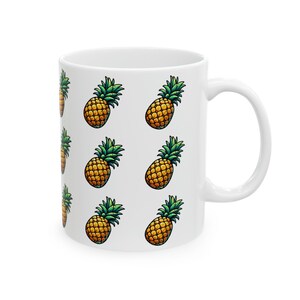 A white ceramic mug with a repeating pattern of pineapple illustrations on its side.