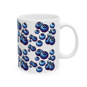 A white ceramic mug with a repeating pattern of blueberries on its surface.