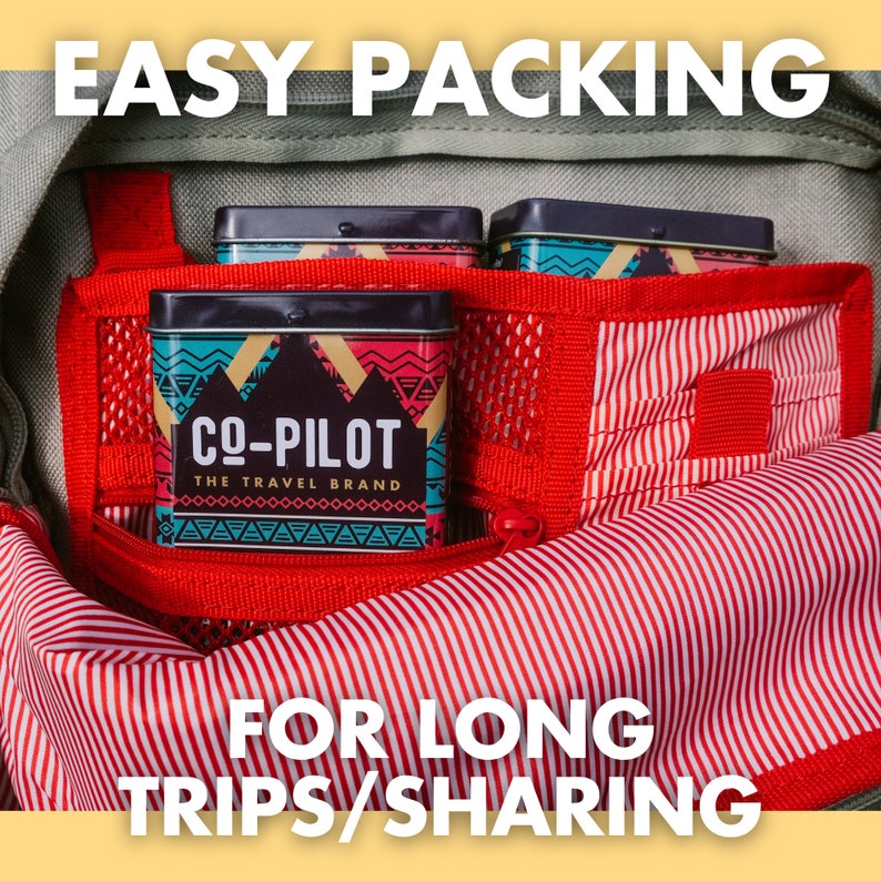 May include: Three small, rectangular, metal tins with a red, white, and blue geometric pattern. The tins are labeled "CO-PILOT THE TRAVEL BRAND". The tins are in a red and white striped bag with a zipper.