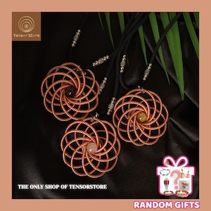 May include: Three copper-colored wire pendant necklaces with intricate spiral designs, each featuring a different gemstone: amethyst, rose quartz, and citrine. The necklaces hang against a black background, with the text "THE ONLY SHOP OF TENSORSTORE" visible.