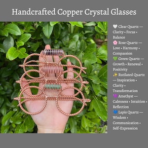 Könnte beinhalten: Handgefertigte Kupferdrahtbrille mit drei horizontalen Kristallstäben in Lila, Rosa und Grün. Der Text lautet Handcrafted Copper Crystal Glasses und listet Kristalle wie Bergkristall, Rosenquarz, grünen Quarz, Rutilquarz, Amethyst und Lapisquarz mit ihren Bedeutungen auf.
