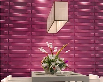 Op de afbeelding: Een moderne eetkamer met een magenta textuurmuur. Een witte tafel is gedekt met een bloemstuk, wijnglazen en een wijnfles. Een geometrische hanglamp hangt boven de tafel en verlicht de scène.