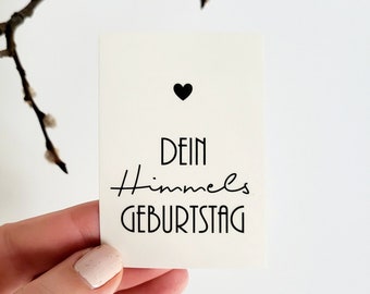 Può includere: Un biglietto bianco con testo nero che recita "Dein Himmels Geburtstag" con un piccolo cuore nero sopra il testo.