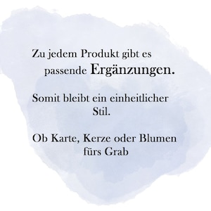 May include: White background with a blue watercolor wash and black text. The text reads: "Zu jedem Produkt gibt es passende Erg&auml;nzungen. Somit bleibt ein einheitlicher Stil. Ob Karte, Kerze oder Blumen f&uuml;rs Grab."