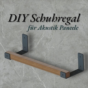 May include: A wooden shelf with dark gray metal brackets. The shelf is made of light brown wood and is supported by two L-shaped brackets. The text "DIY Schubregal für Akustik Paneele" is at the top.