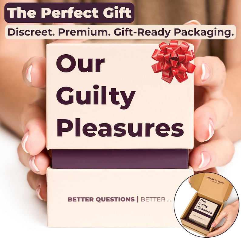 Hands holding the beige Our Guilty Pleasures card game box with a dark purple center and a red gift bow on top, showing the front of the packaging with "Our Guilty Pleasures" printed clearly. The image depicts the card game as "The Perfect Gift".