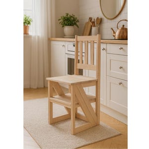 May include: A light-colored wooden step stool chair with a slatted back and a small step. The chair is made of unfinished wood and is placed on a beige rug in a kitchen setting. The chair is designed to provide extra height.