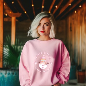 May include: Pink sweatshirt with a snowman graphic and the text "Freeze a Jolly Good Fellow".