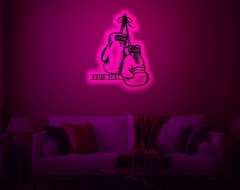 May include: A black and white illustration of two boxing gloves hanging from a hook. The gloves are labeled "NAME" and the text "YOUR TEXT" is below the gloves. The illustration is on a pink wall in a room with a couch and a lamp.