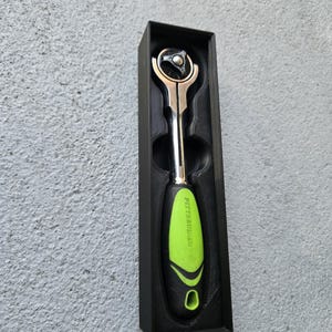 May include: A silver and black ratchet wrench with a green handle, presented in a black box. The handle has the brand name "PITTSBURGH" printed on it. The tool is designed for mechanical work.