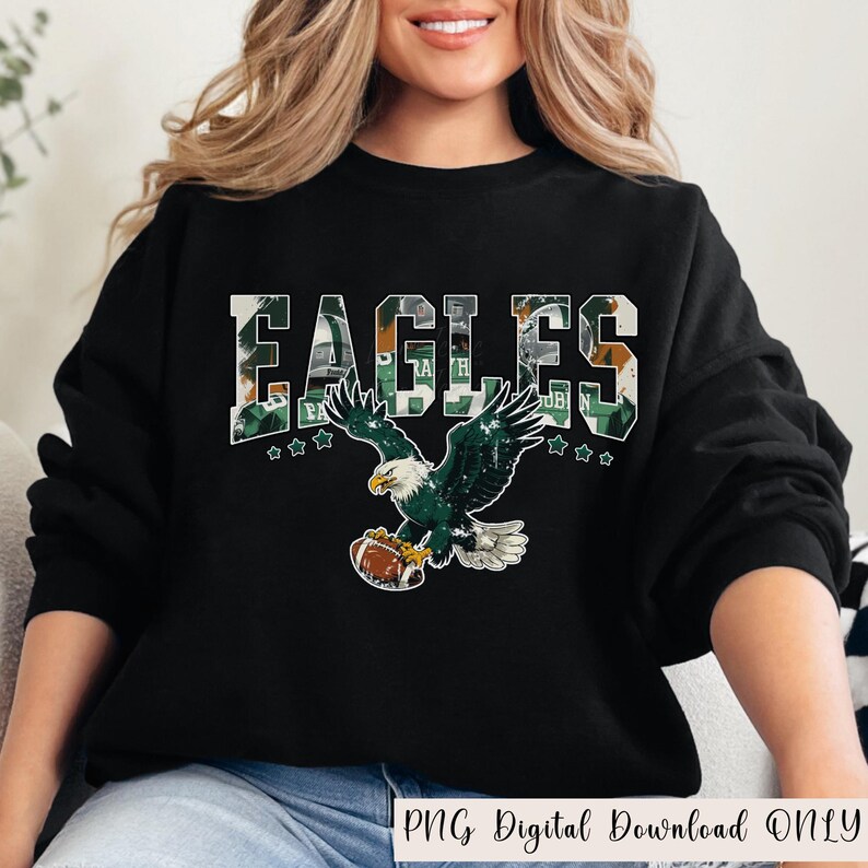May include: Black sweatshirt with the word "EAGLES" in a green and white camouflage pattern. Below the word is a graphic of an eagle holding a football. The text "PNG Digital Download ONLY" is at the bottom.