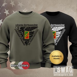 May include: Two sweatshirts, one olive green and one black, featuring a triangular emblem with text in French. The emblem includes the words "LÉGION ÉTRANGÈRE" and "2 RÉGIMENT ÉTRANGER DE PARACHUTISTES". The black sweatshirt has a white emblem. The olive green sweatshirt has a "More colors" option.