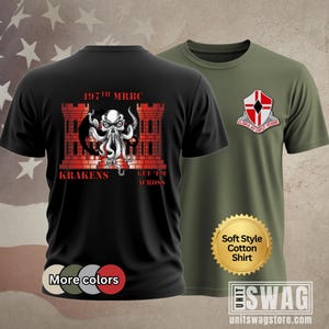 May include: Two short-sleeved cotton shirts. One black shirt features a red and white Kraken design with the text "197th MRBC KRAKENS GET 'EM ACROSS." The other is olive green with a crest that reads "GLORIA AD CAPUT VENIRE."