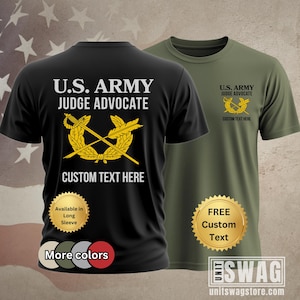 May include: Black and olive green t-shirts with the text "U.S. ARMY JUDGE ADVOCATE" and a gold emblem. The black shirt has "CUSTOM TEXT HERE" below the emblem and a "More colors" button. The olive green shirt has "FREE Custom Text" on a gold seal.