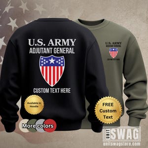 May include: Black and olive green sweatshirts with the text "U.S. ARMY ADJUTANT GENERAL" and a shield graphic. The black sweatshirt has "CUSTOM TEXT HERE" below the graphic. The olive green sweatshirt has the same text and graphic on the chest.