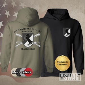May include: A green hooded sweatshirt with the text "11th Armored Cavalry Regiment Blackhorse" and a black horse logo. The sweatshirt is available in other colors and as a sweatshirt.