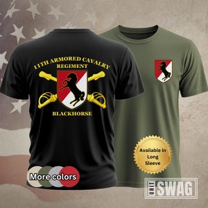 May include: Black and olive green t-shirts. The black shirt features the text "11th ARMORED CAVALRY REGIMENT BLACKHORSE" with a horse emblem. The olive green shirt has a smaller emblem. The shirts are available in long sleeve.