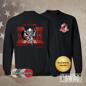 May include: Black sweatshirt with a red graphic of a castle and a kraken with the text "197th MRBC KRAKENS GET 'EM ACROSS". The right sleeve has a red and white shield with the text "DEUS ADJUVAT QUI CAPUT VIRIDIS". The sweatshirt is available in hoodie style.