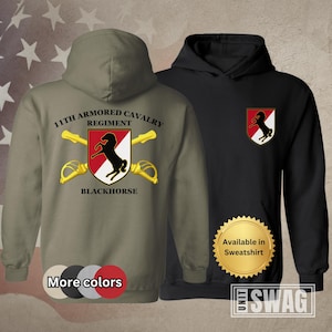 May include: A green hooded sweatshirt with the text "11th Armored Cavalry Regiment Blackhorse" and a red and white shield with a black horse. The sweatshirt is available in other colors.