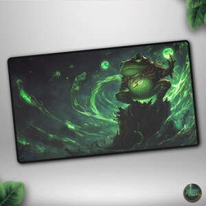 May include: A rectangular mousepad featuring a fantasy illustration of a large green frog with glowing orbs and swirling green energy. The frog is perched on a dark, textured surface, set against a dark, atmospheric background.