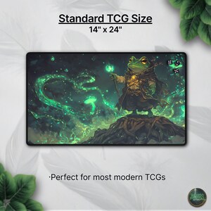 May include: A rectangular gaming mat with a fantasy illustration of a frog wizard holding a glowing staff. The mat is 14 inches by 24 inches and features green and black colors. Text at the top reads "Standard TCG Size".