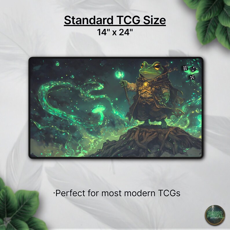May include: A rectangular gaming mat with a fantasy illustration of a frog wizard holding a glowing staff. The mat is 14 inches by 24 inches and features green and black colors. Text at the top reads "Standard TCG Size".