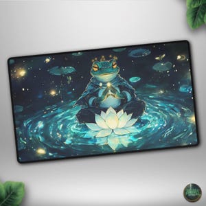 May include: A rectangular mousepad featuring a serene illustration of a meditating frog. The frog, with a crown, is seated on a lotus flower in a pool of water, surrounded by a starry night sky. The color palette includes blues, greens, and whites.
