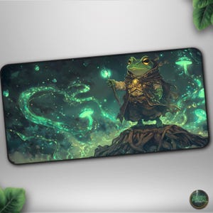 May include: A rectangular mousepad featuring a green frog wizard holding a glowing staff. The frog stands on a tree root, surrounded by glowing green swirls and mushrooms against a dark, starry background. The mousepad has a black border.