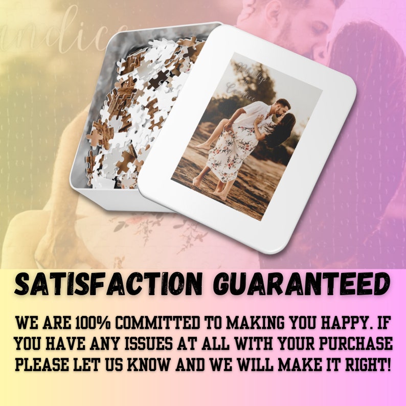 May include: A white metal box containing a jigsaw puzzle. The box features a photograph of a couple kissing on a beach. The text "SATISFACTION GUARANTEED" is printed at the bottom of the image.