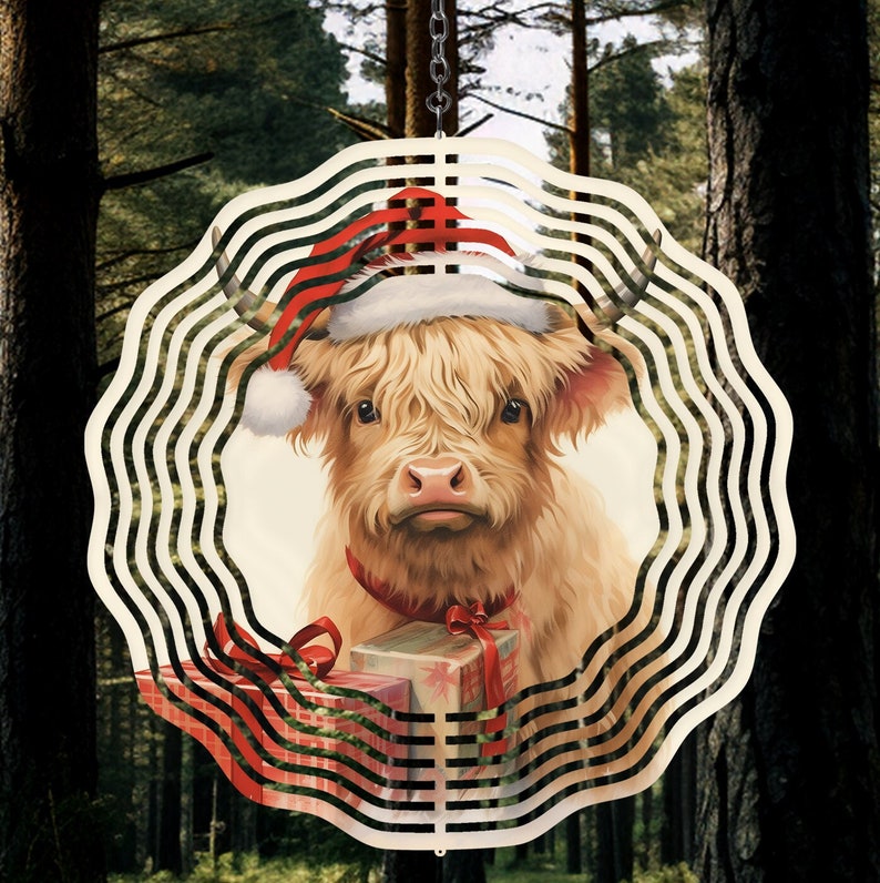 May include: A white and brown Highland cow wearing a red Santa hat and holding a red and white striped gift box. The cow is surrounded by a white and black metal wind spinner.